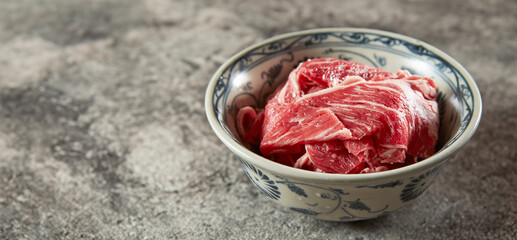 Thinly sliced raw meat in a bowl	