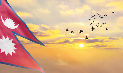 Waving flag of Nepal against the background of a sunset or sunrise. Nepal flag for Independence Day. The symbol of the state on wavy fabric. - obrazy, fototapety, plakaty