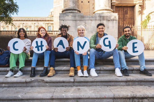 Diverse group of students holding 'CHANGE' signs in an activism campaign. Young people protesting for social justice, equality and reform. Concept of youth movement, empowerment and community.