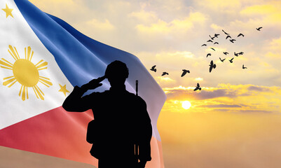 Silhouette of a soldier with the Philippines flag stands against the background of a sunset or sunrise. Concept of national holidays. Commemoration Day.