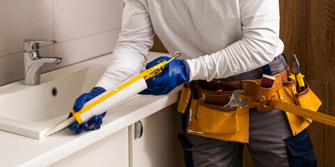 men fixing a sink in bathroom