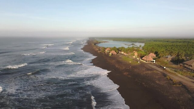 Drone flying backwards at black sand beach El paredon Guatemala