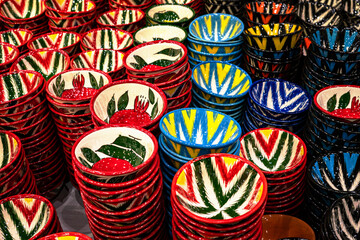 A selection of small bowls lined up for sale in Bukhara, Uzbekistan but taken with a diagonal aspect to display the various colour chioces