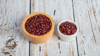 Red kidney beans in white cup on wood background