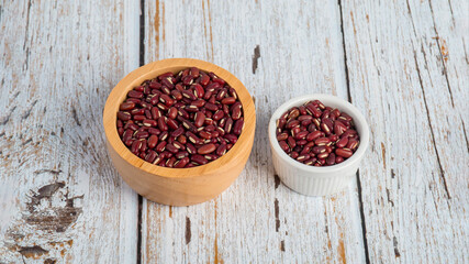 Obraz na płótnie Canvas Red kidney beans in white cup on wood background