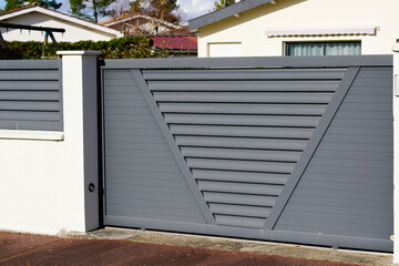 gray sliding gate of the detached house with slide portal door facade in suburb