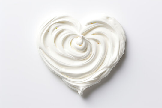 White whipped cream in the shape of a heart on a white background.