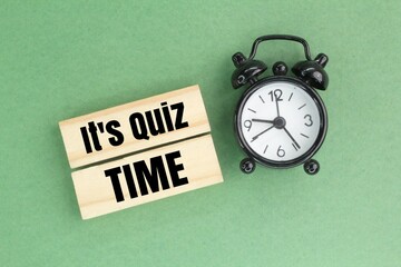 bell and stick clock with the words Its Quiz Time. the concept of answering quizzes or quiz games