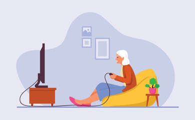 grandmother plays video games or computer games while sitting on a comfortable armchair at home