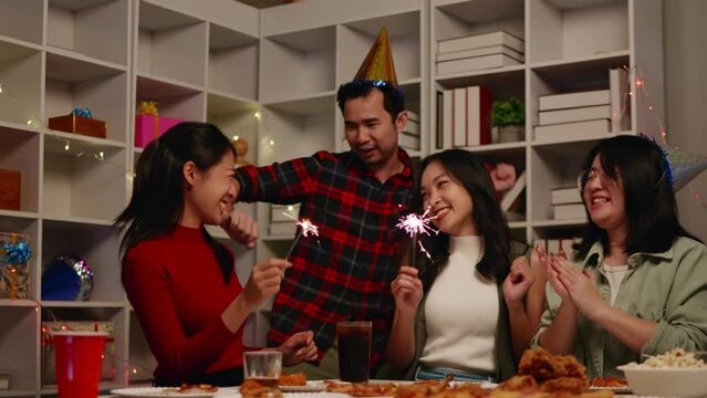 Friends play sparklers and celebrate the party with eating foods and drinks. Happy and joyful in holiday weekend and festival.