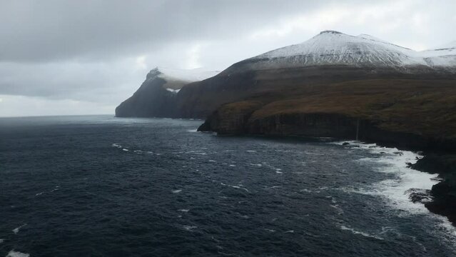 Faroe Islands, 4K Aerial of &lrm;Ni&eth;ara Vatn waterfall with beautiful mountains in the background.