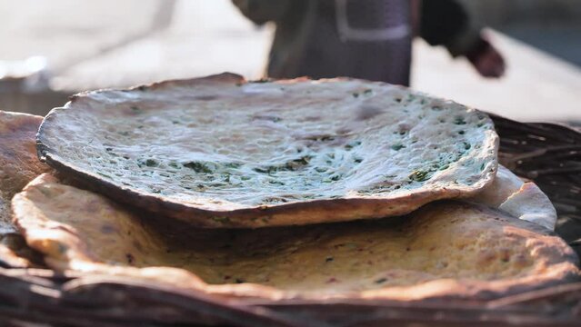 Traditional Uzbek flatbreads baked in a tandoor oven. Freshly baked hot bread is placed in a wicker basket