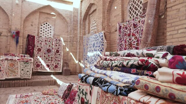 Shop of traditional oriental carpets and handmade fabrics. Traditional craft of Uzbekistan. Selling carpets in a craftsman's workshop