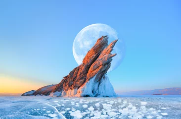 Fotobehang Ogoy island on winter Baikal lake with transparent cracked blue ice with full moon at sunrise - Baikal, Siberia, Russia "Elements of this image furnished by NASA" © muratart