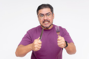 An impatient angry middle aged man holding a fork and knife seething with rage. Demanding to know...