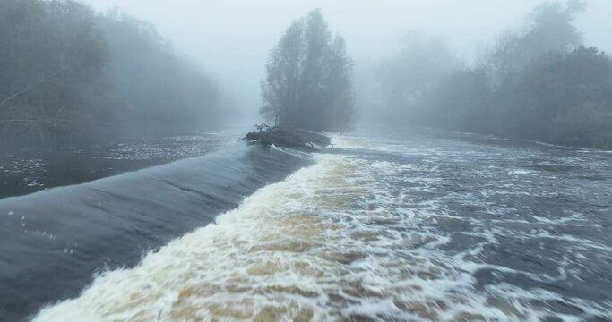 A waterfall in the foggy river in 4k