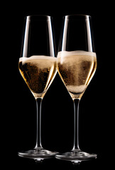 Pair crystal-clear flute glass of champagne isolated on black background