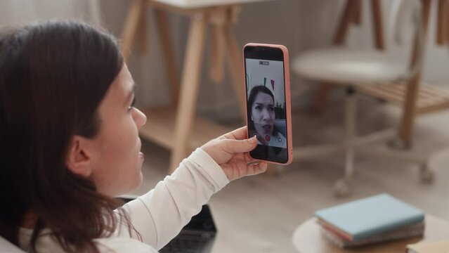 Medium Closeup Of Young Caucasian Woman With Dwarfism Sitting On Couch In Living Room And Recording Video Of Herself On Smartphone, Sharing Stories On Camera