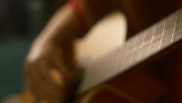 Defocused background, 4k view guitarist hands playing the guitar plucking the strings of a six-string guitar. Classical music, copy space.  