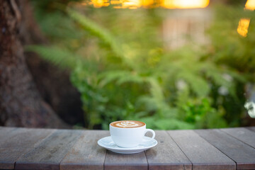 Hot art Latte Coffee. Background Coffee cup and beans on old kitchen table. 
