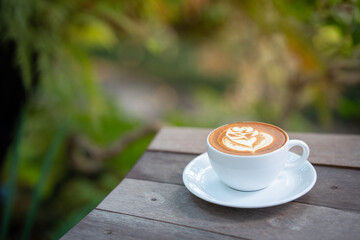 Hot art Latte Coffee. Background Coffee cup and beans on old kitchen table. 