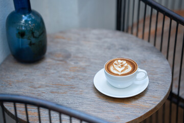 Hot art Latte Coffee. Background Coffee cup and beans on old kitchen table. 