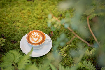 Hot art Latte Coffee. Background Coffee cup and beans on old kitchen table. 