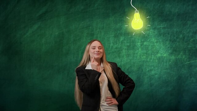 Portrait of woman isolated on green background light bulbs image on top. Girl standing looking up at lighted yellow lamp bulb, smiling happy with new idea.
