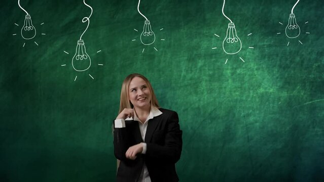 Portrait of woman isolated on green background light bulbs image on top. Girl standing thinking and wondering looking up, pointing smiling, lamp lights up.