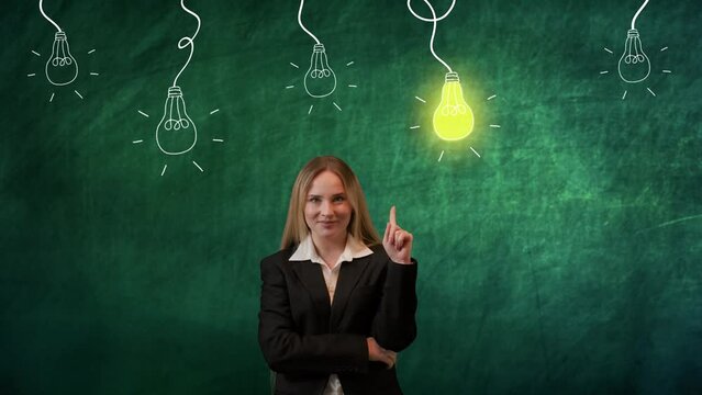 Portrait of woman isolated on green background light bulbs image on top. Girl standing thinking smiling at camera pointing finger having idea, lamp lights up.