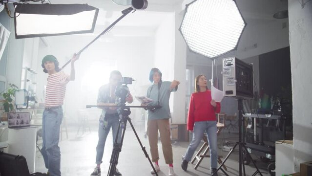 Zoom in Portrait of a Group of Young Film Students Working on their School Project. Creative Crew Filming a Fun Music Video for a Female Artist, Using High Quality Equipment. Slow Motion