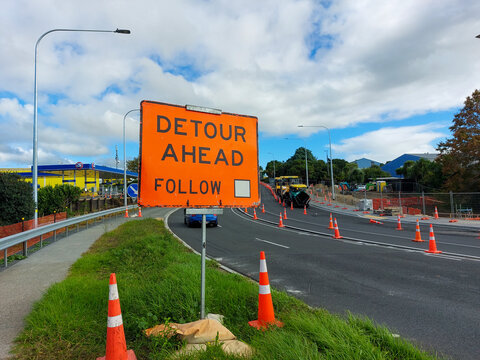 Road sign saying 'Detour ahead' and orange cones, Auckland