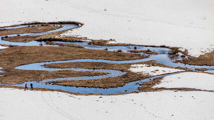 Explorers trek through rugged terrain.