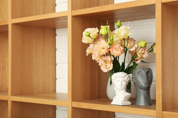 A vase with flowers on a wooden shelf