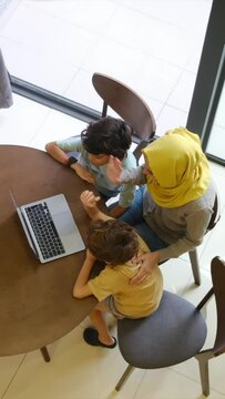 Muslim family video conference with laptop during Eid Adha, Ramadan, Aid Fitar holiday. Connect with the family from a distance, always connected, transnational family.