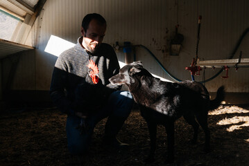 Male with black dog and chicken in farm © GALDRIC