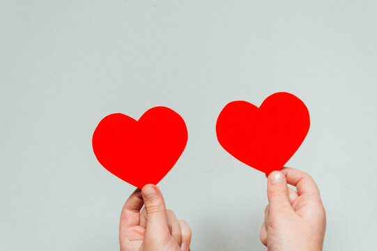 Red heart in children's hands on white background. High quality photo