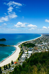 Obraz premium Landscape scenario of a bay with sandy white beach and turquoise sea. Maunganui beach and Moturiki Island , Tauranga, New Zealand. Travel destination