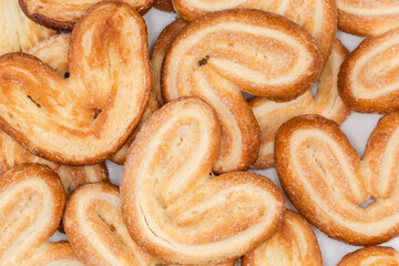 Heap of puff pastry butterfly cookies, top view close-up