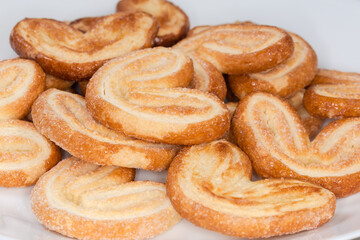 Heap of puff pastry butterfly cookies, side view close-up © An-T