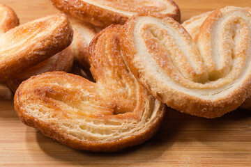 Puff pastry butterfly cookies on a wooden surface close-up