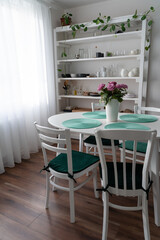 Table setting in the living room. Flowers in a vase on the table. Table decor for the arrival of guests.