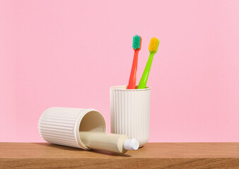 Two brightly colored toothbrushes stand in the toothbrush container. The toothpaste refresher lies...