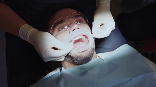 Dentist cleans a man's teeth. Hydience and healthy in modern clinic. Healthcare. Protective glasses