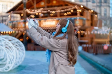 Crédence de cuisine en verre imprimé Magasin de musique smiling young woman  having a fun time in Christmas market , using phones at outdoor in urban city. people, communication,  shopping and lifestyle concept