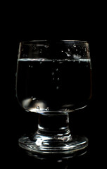 Clean water in a glass on a black background