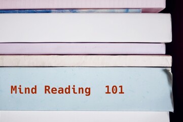 Book on shelve with text written on spine MIND READING 101 - means ability to know what is going on in someone's mind without asking them to clarify - obrazy, fototapety, plakaty
