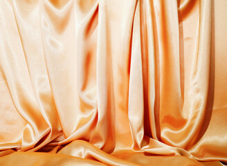 BackdropYellow silk satin  Drape fabric Gold color Luxurious background. Beautiful wavy area for design, blurred or blurred.