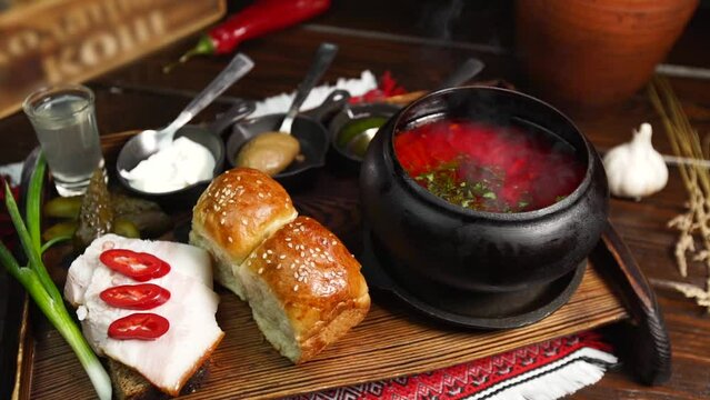 Beautiful serving of ukrainian borscht with salo pampushkas and tincture