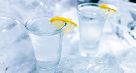 Two glasses of vodka with ice and lemon